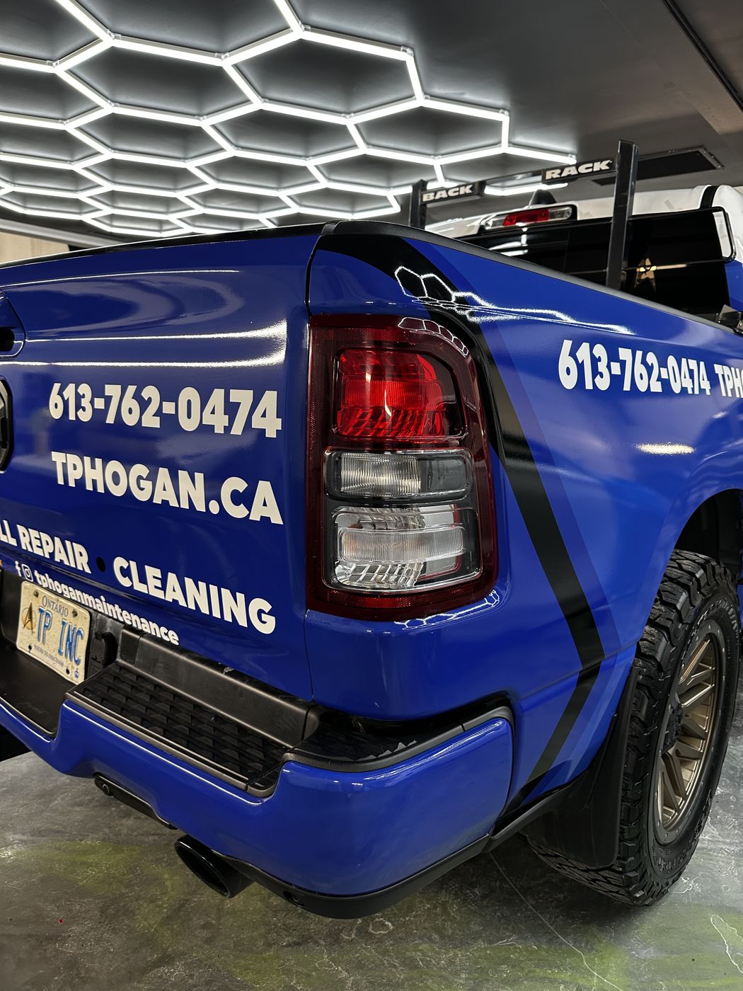 Cut-vinyl contact lettering on a blue RAM 1500 tailgate and bed