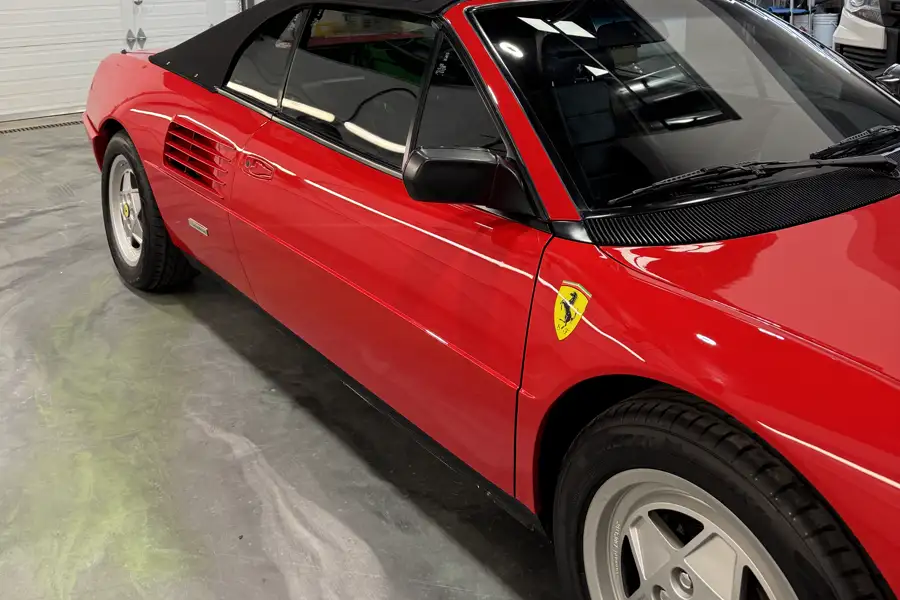 Side sweep of a classic red Ferrari in the AutoCore shop
