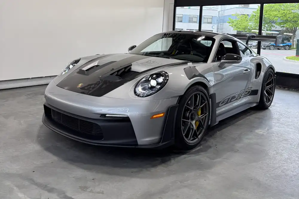 A silver Porsche GT3 RS parked inside the AutoCore Customs shop