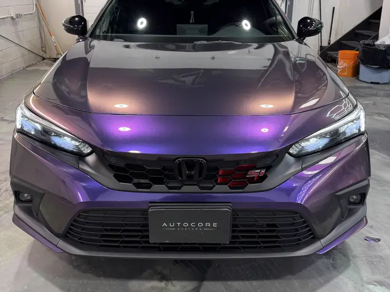 A colour-shift purple Honda Civic Si with an AutoCore Customs plate
