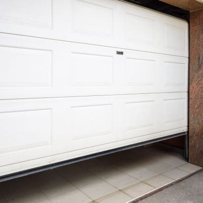 Three custom white garage doors on a spacious modern home