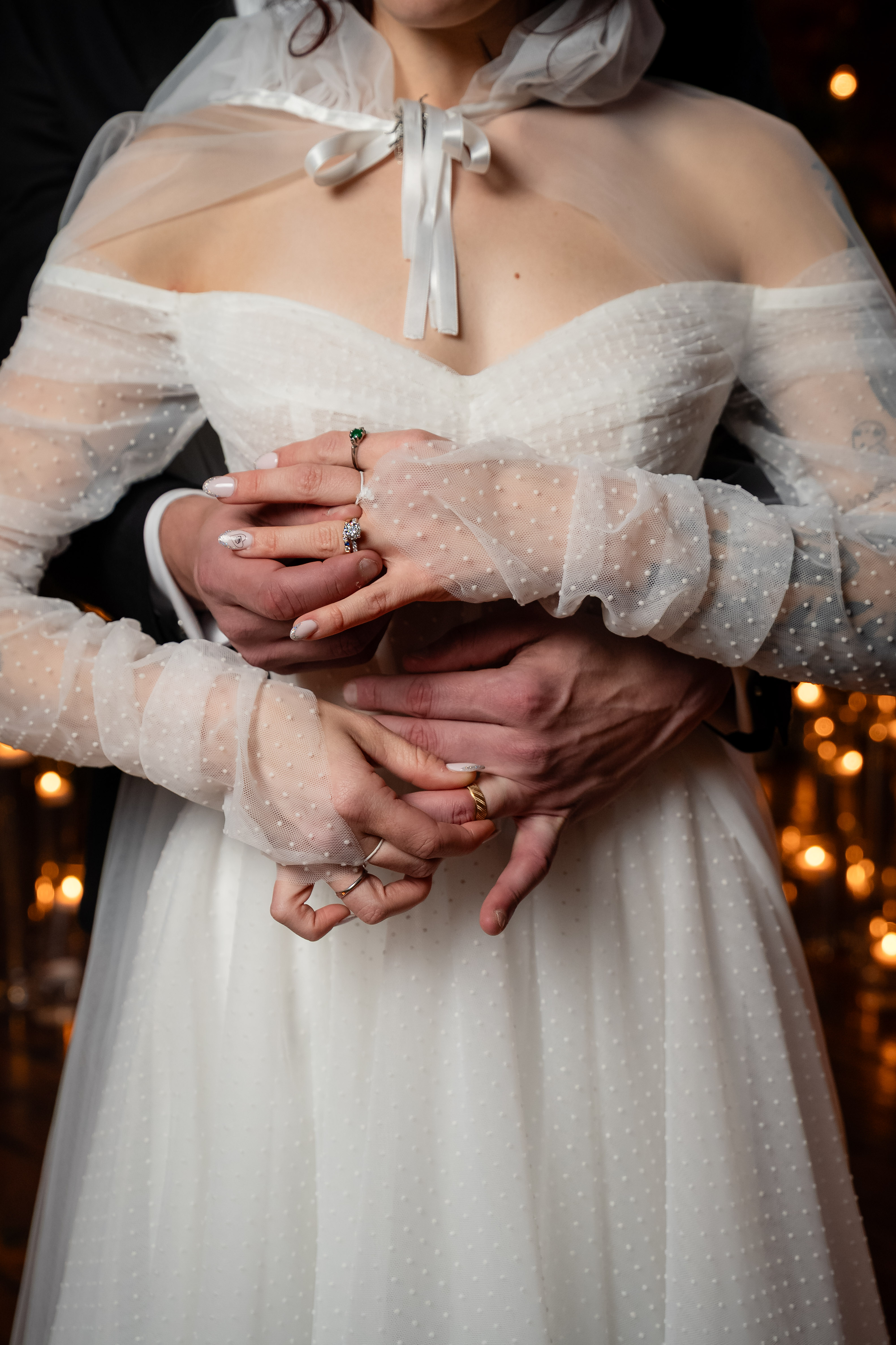 Hands resting at the waist of a lace gown