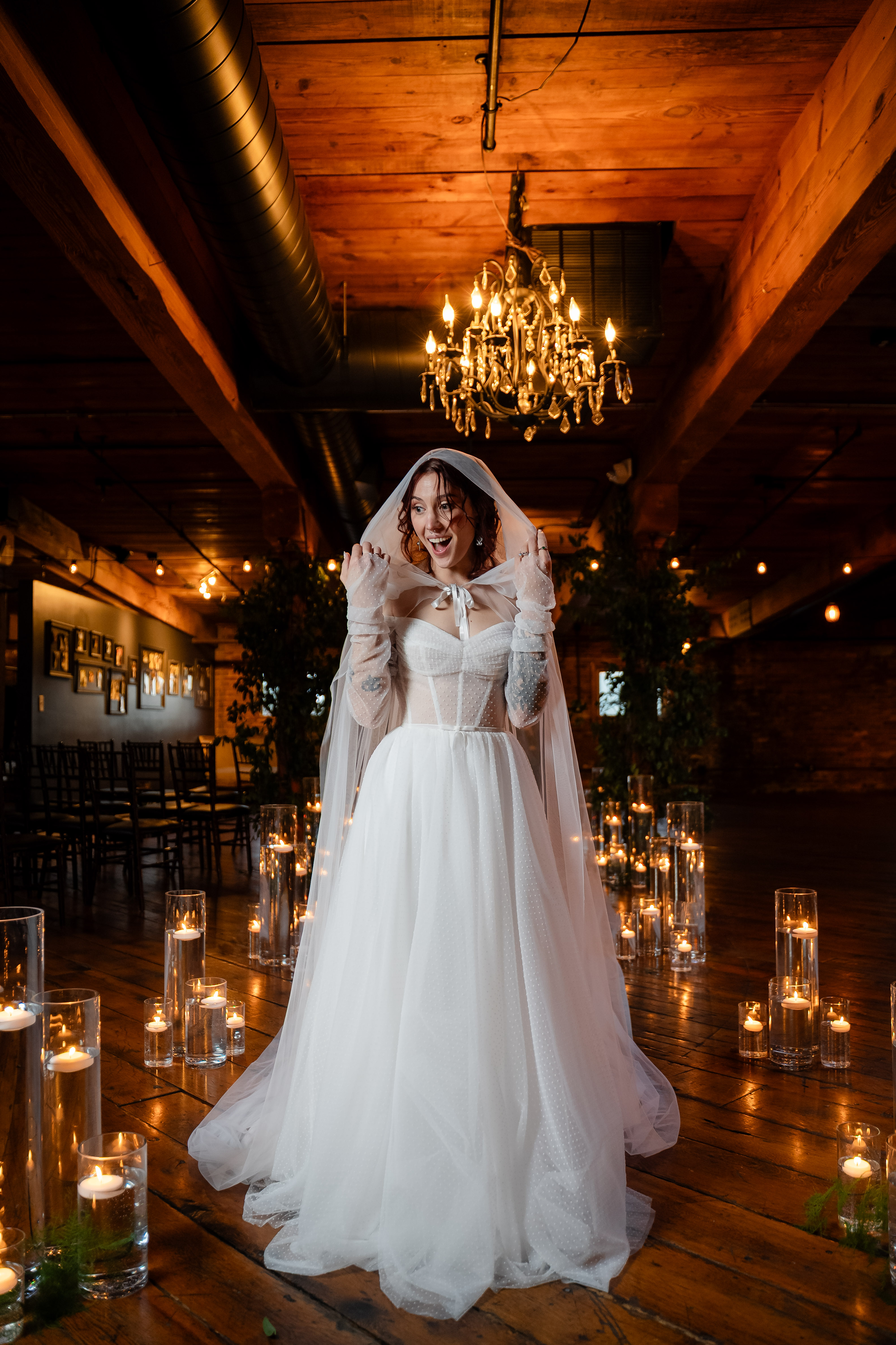 Bride standing alone under chandeliers