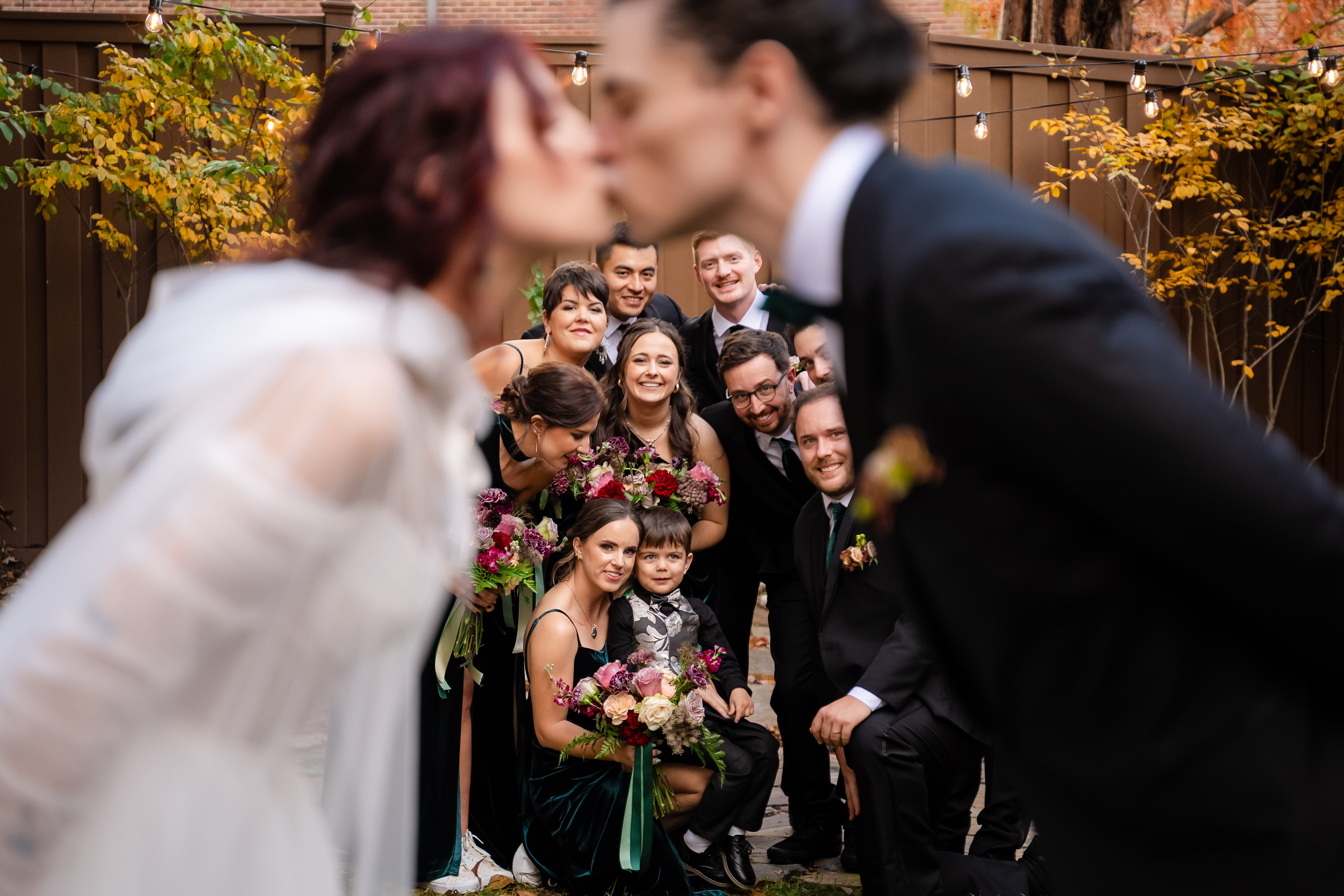 Couple kissing inside a ring of cheering friends
