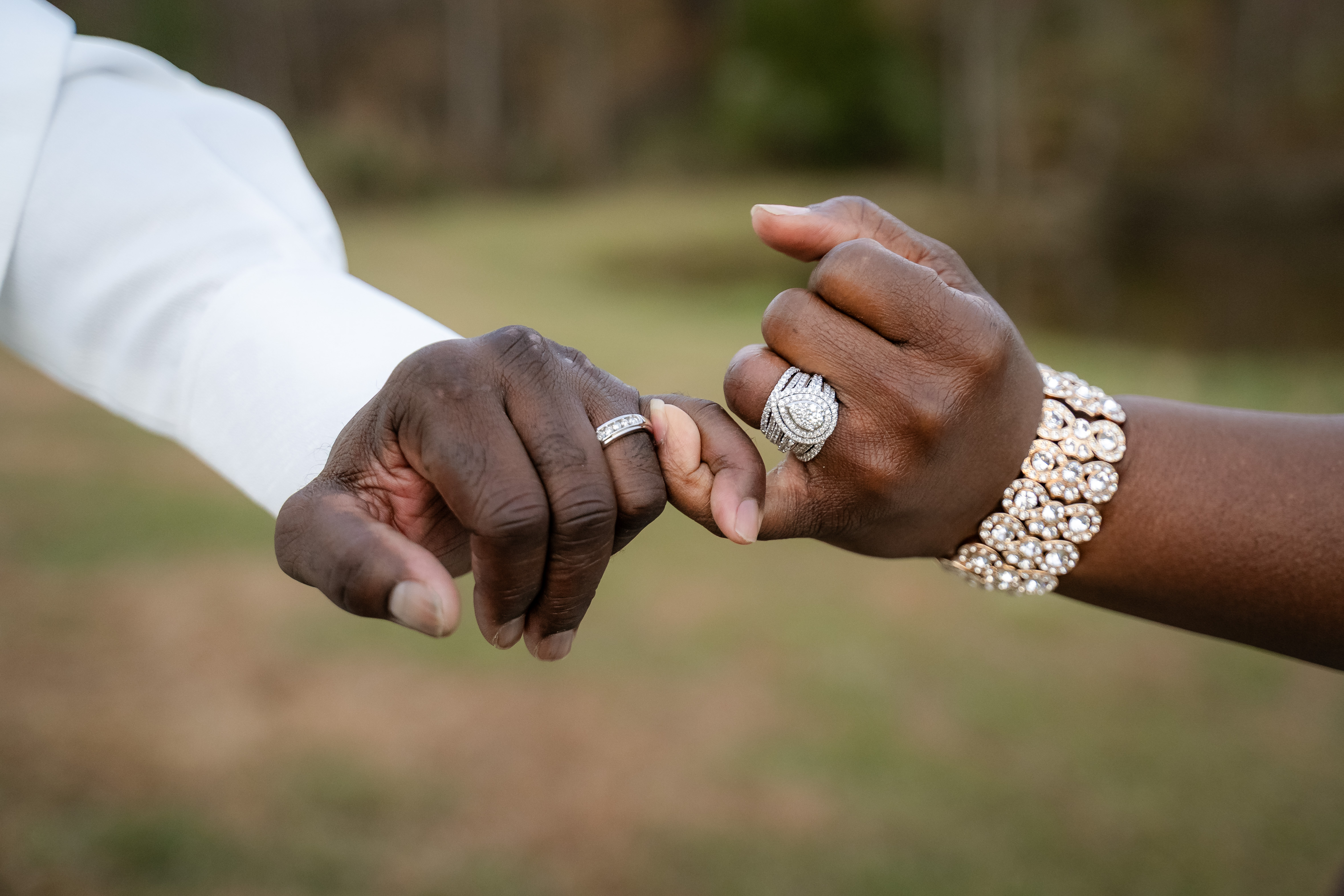 Two hands together showing their wedding rings