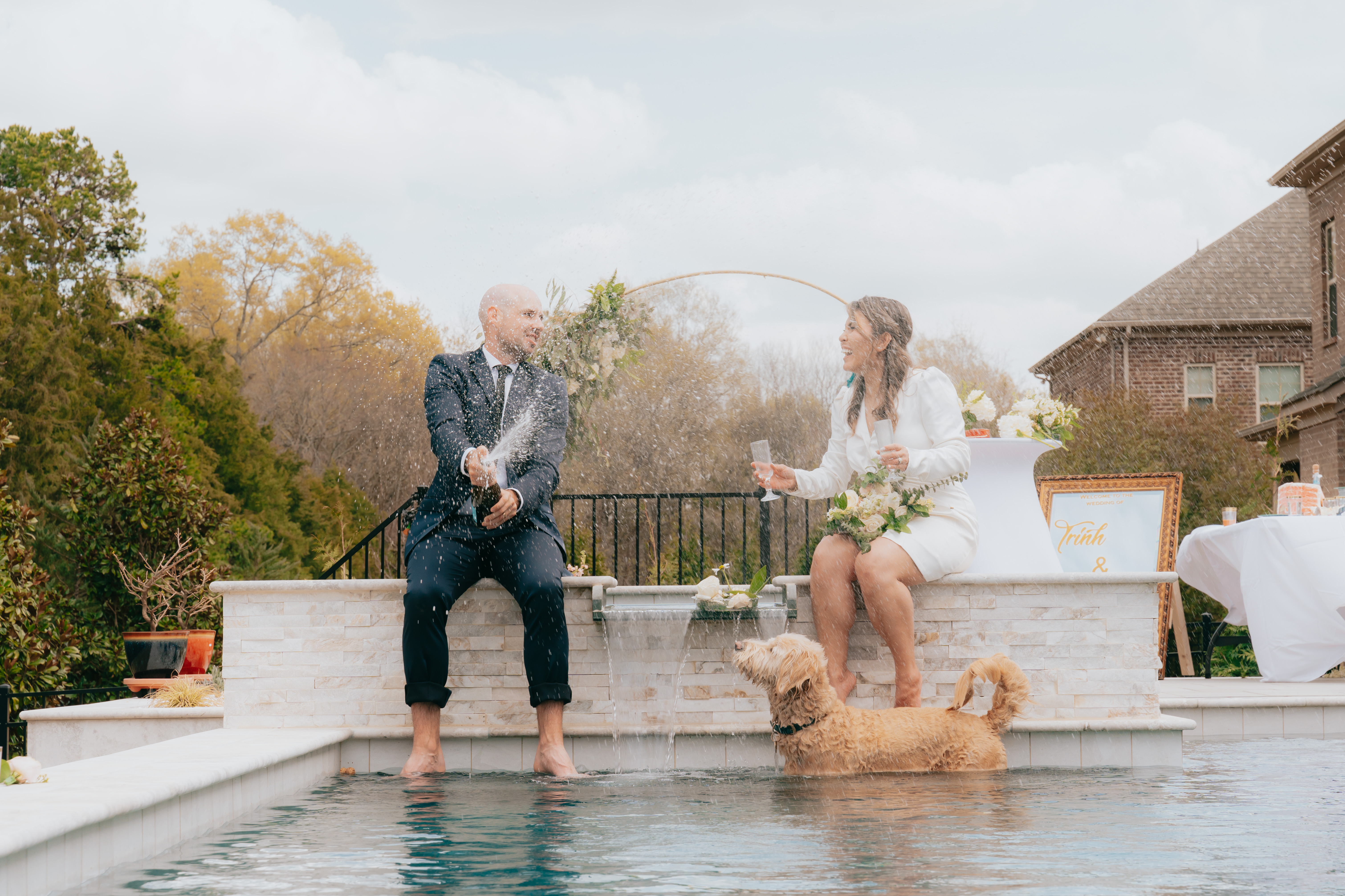 Couple opening champagne beside the water in autumn