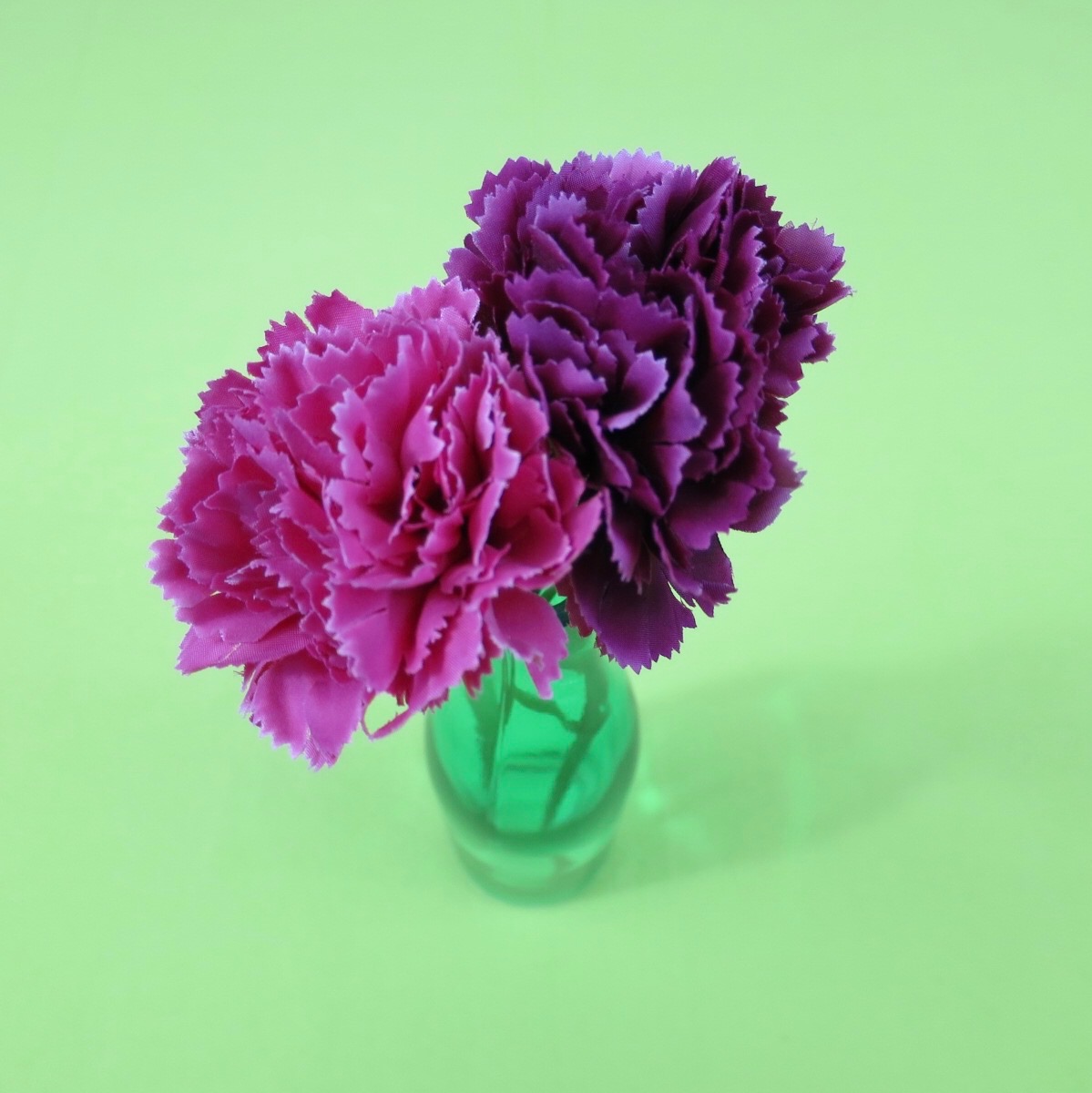 Pink and purple flowers in green vase