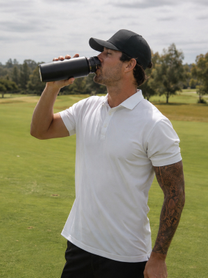 Golfer drinking from a bottle on the course