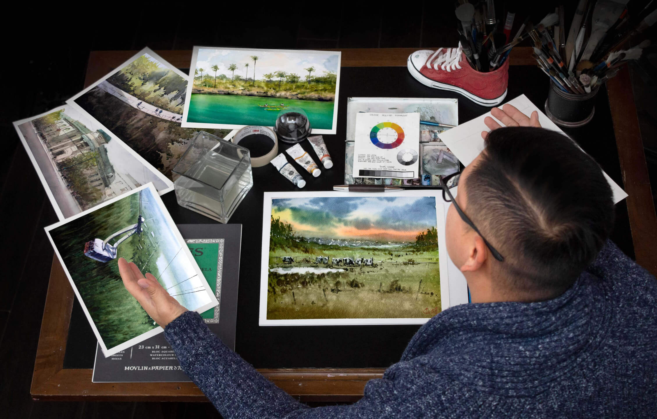 Broderick Wong reviewing watercolor landscape artworks and teaching materials for his online painting course