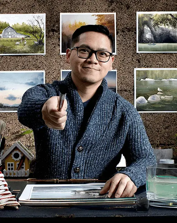 Watercolor artist and instructor Broderick Wong smiling with paintings behind him.