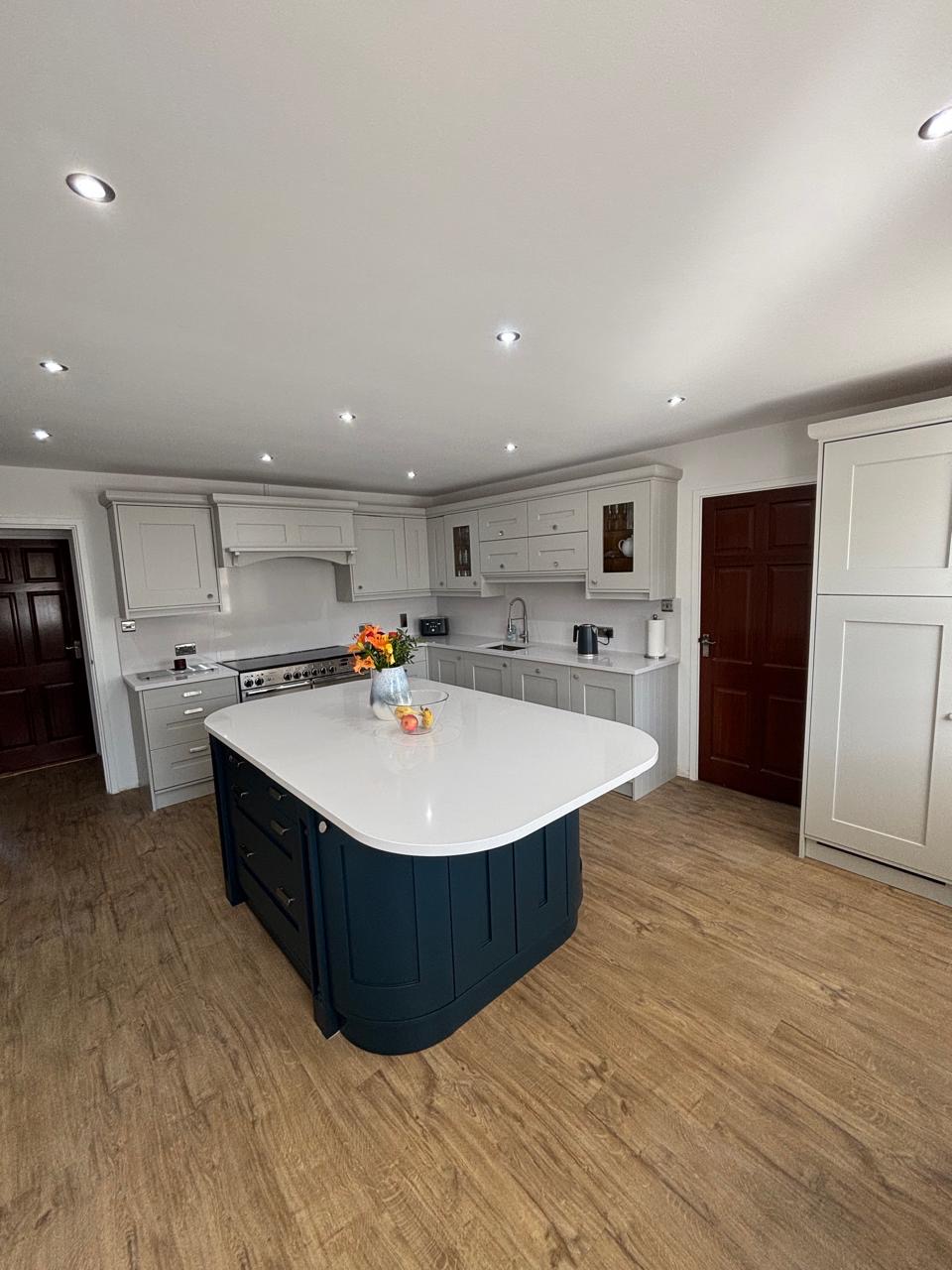 Kitchen with deep navy island after professional respraying in Jersey