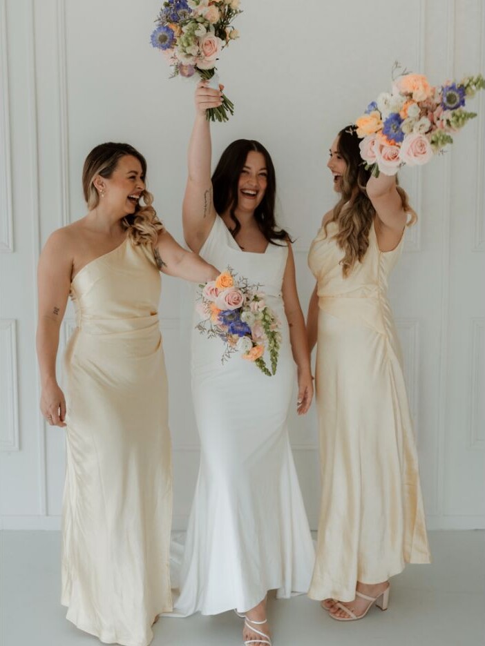 Bride and bridesmaids celebrating together with wedding bouquets