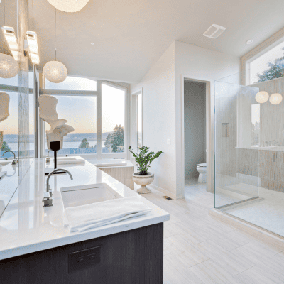 Modern bathroom remodel with glass shower, double vanity, and natural lighting