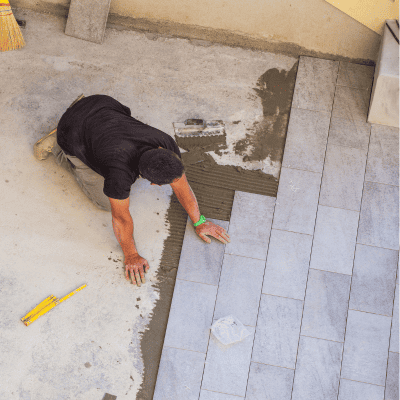 Worker installing large-format tiles during a patio flooring project