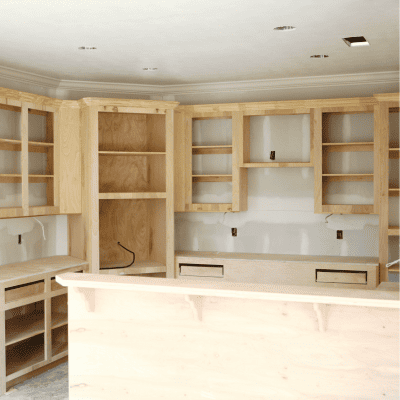 Custom kitchen cabinet installation in progress with wooden shelving