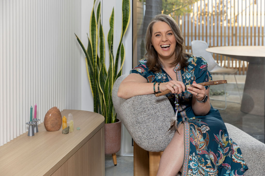 Selena Woodward laughing mid-conversation on a couch