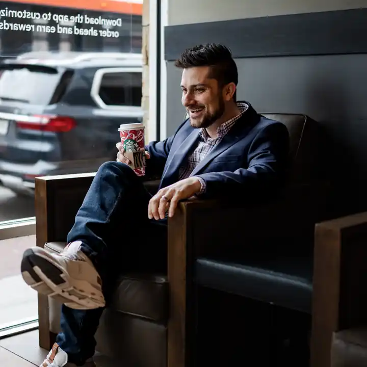 Jordan Sellers in a navy blazer, relaxed in a coffee shop