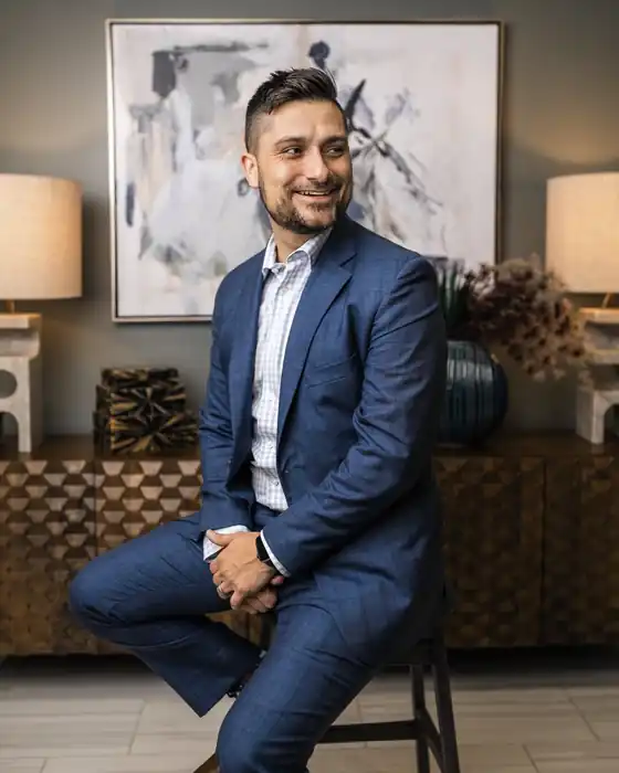 Jordan Sellers in a blue suit, seated on a stool
