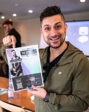 Jordan holding a flyer for The Social Shift event with his name on it