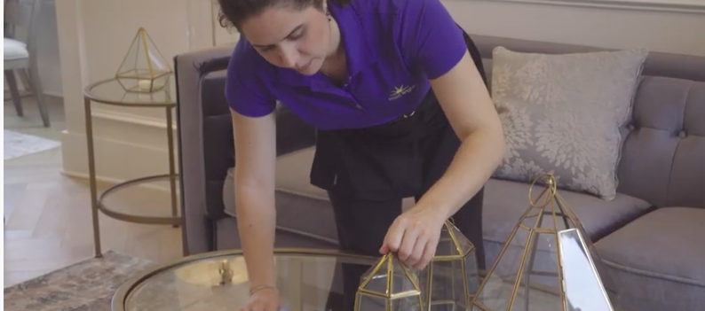 maid dusting while cleaning a house