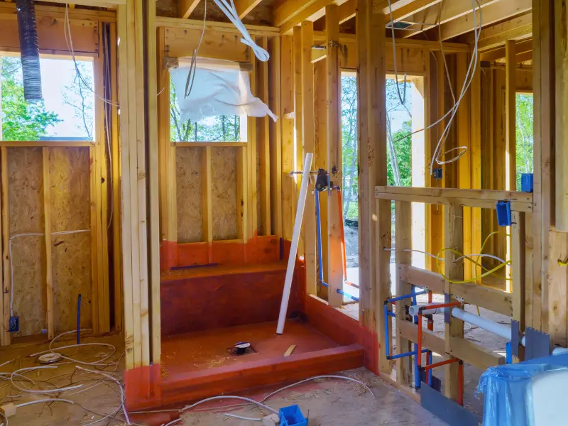 Copper and PEX plumbing lines routed through a house under renovation.