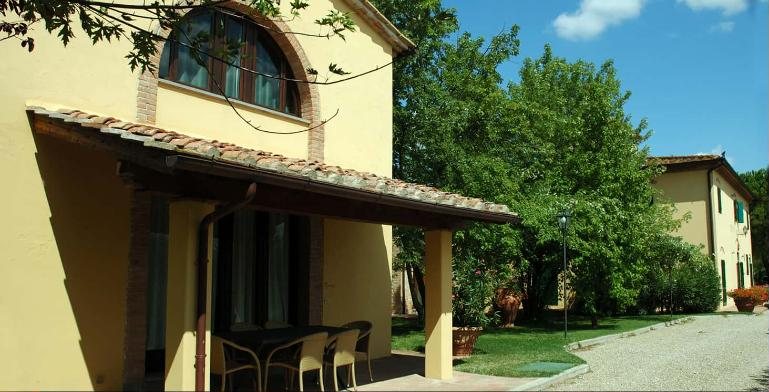 Girasole, a yellow farmhouse with an arched window and a covered patio in the sun