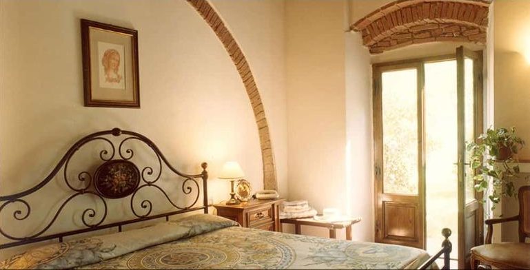 Rosmarino double bedroom under a brick arch, with garden doors