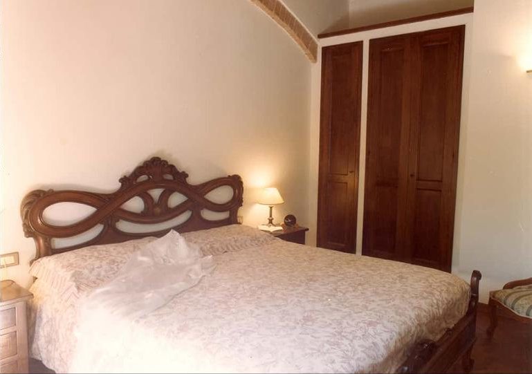 Rosa bedroom with a carved wooden double bed
