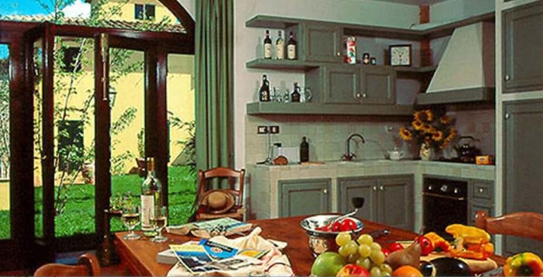 Salvia kitchen in sage green with arched glass doors to the garden