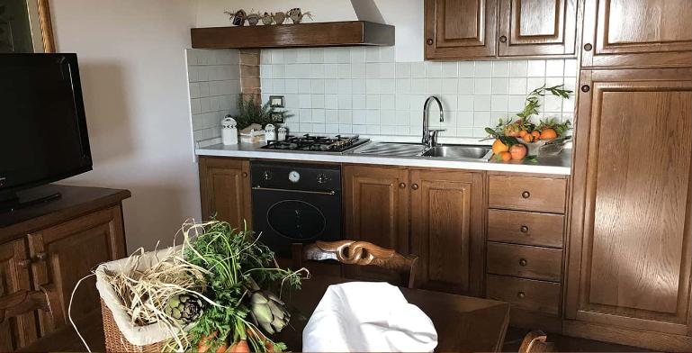 Vigna kitchen in warm oak with a basket of artichokes and greens