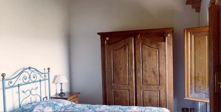 Vigna bedroom with a tall carved wardrobe