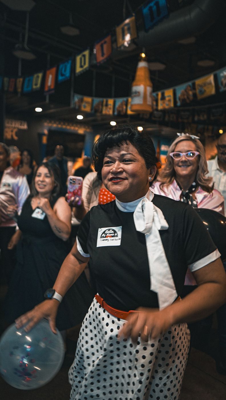 A guest laughing with a balloon, the room behind them.