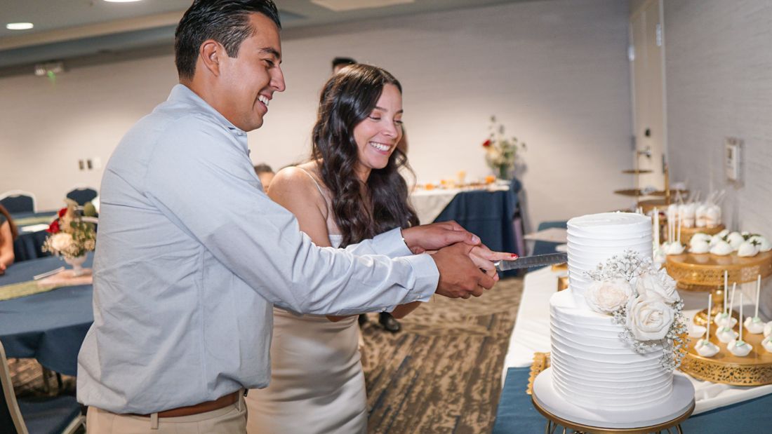 Guests cutting a cake, the room still visible behind them.