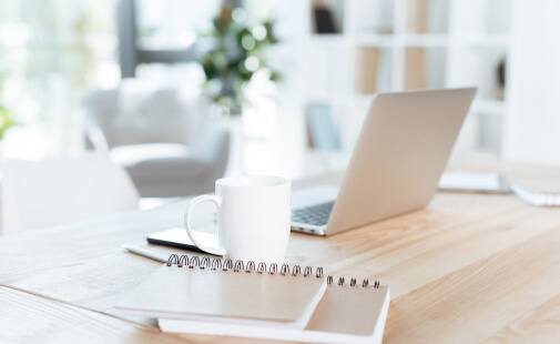 A bright workspace with a laptop and notebook