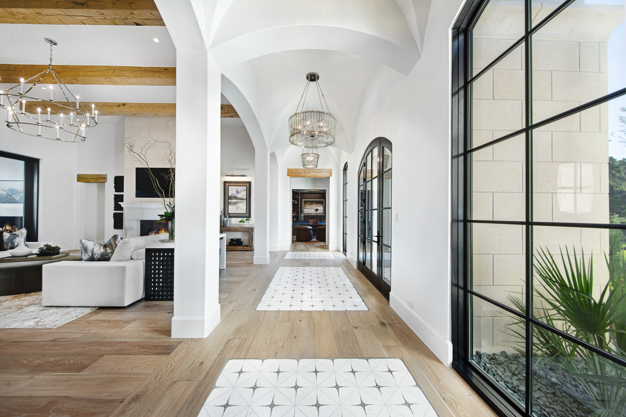 Arched entry hall with iron windows and chandelier