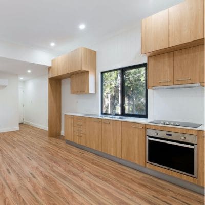 Minimalist kitchen with light wood cabinetry and stainless steel appliances