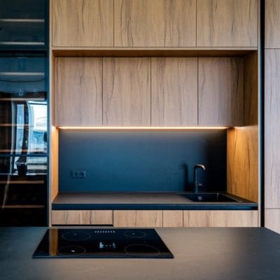 odern kitchen countertop with wood cabinetry and integrated lighting