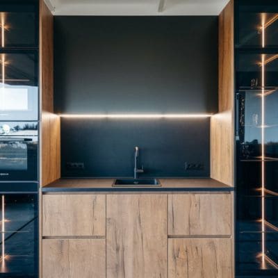 Compact kitchen with wooden cabinets and LED backsplash lighting