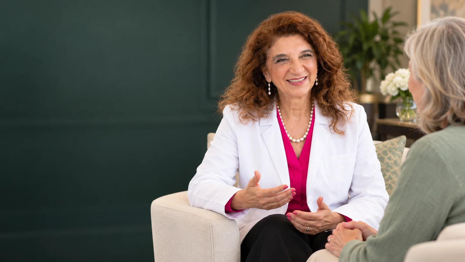 Dr. Dalal Akoury listening attentively to an older woman at AWAREmed in Johnson City, Tennessee.
