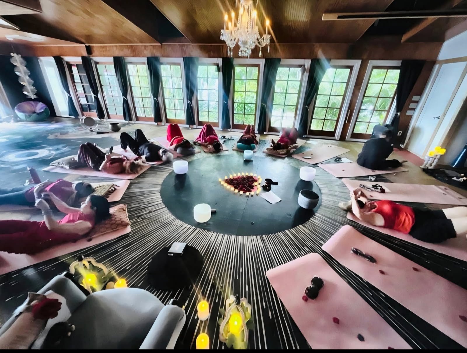 The main room at Moi Space, Fort Myers — mats arranged in a circle beneath chandeliers