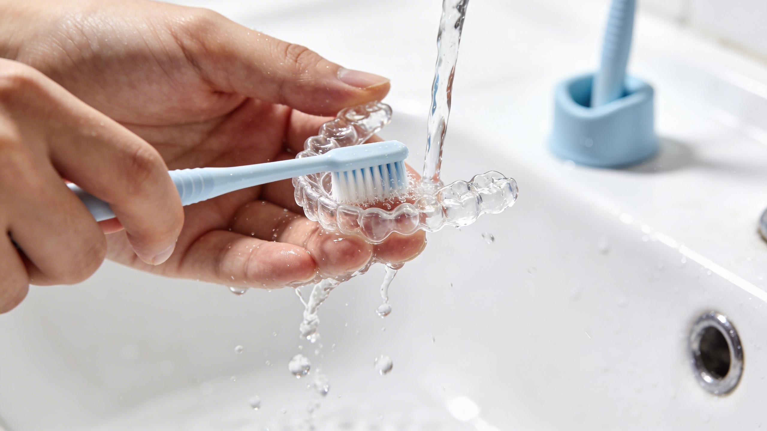 foto de persona limpiando alineador para ortodoncia invisible de invisalign