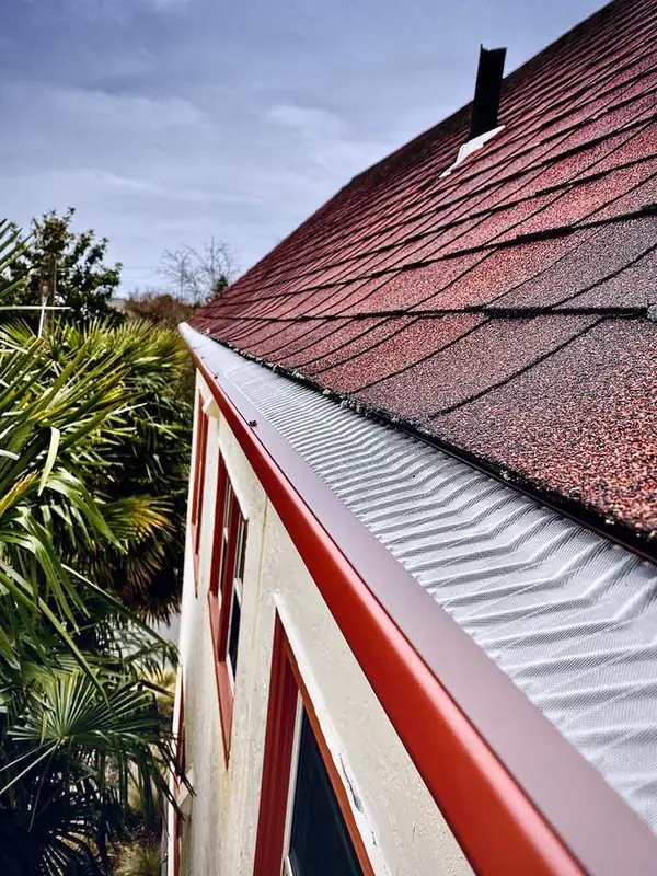 Micro-mesh gutter guard installed along a red roof