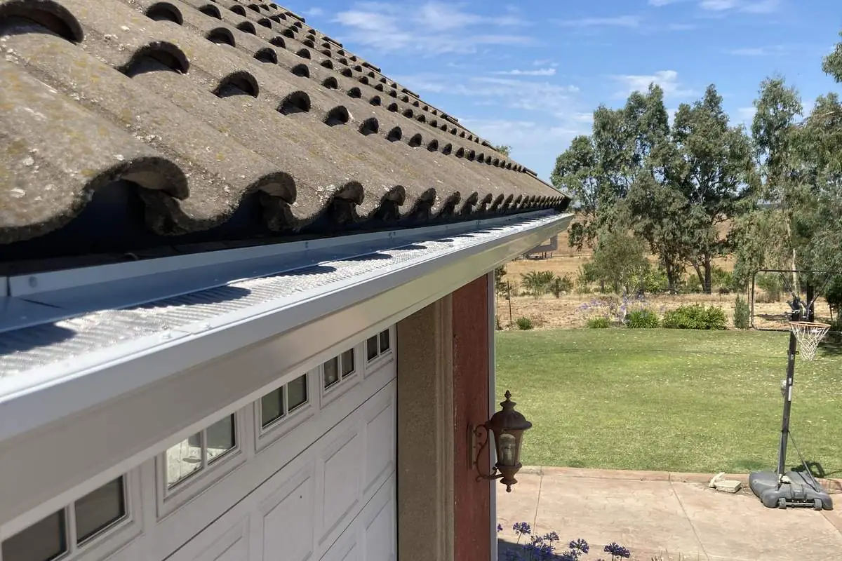 Micro-mesh gutter guard installed on a white gutter
