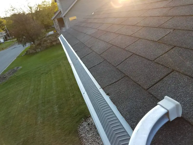 Long gutter guard installation along a shingle roof