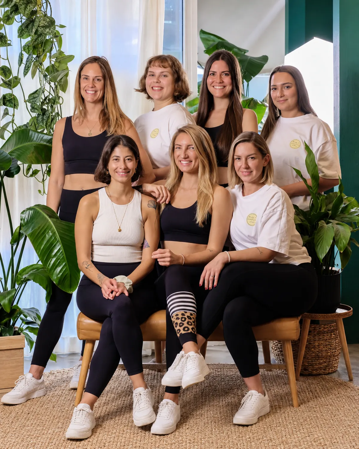 The Good Gym team, seven smiling women, in the plant-filled studio in Maxvorstadt