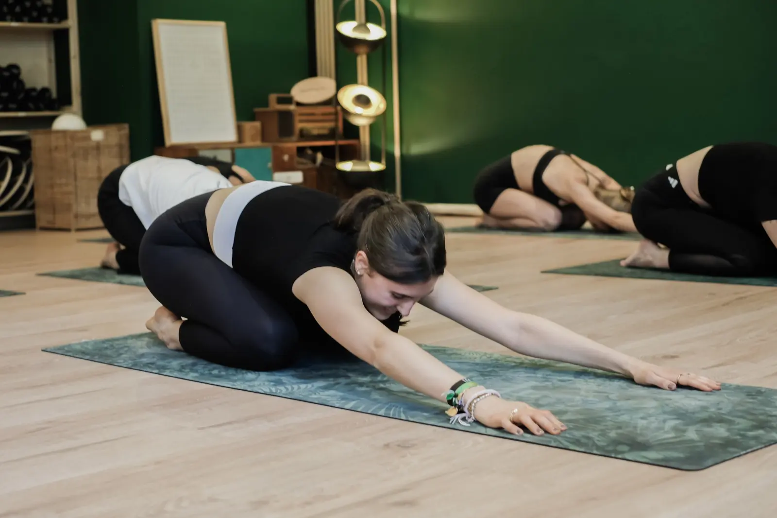 Women stretching into child pose on their mats during a yoga class