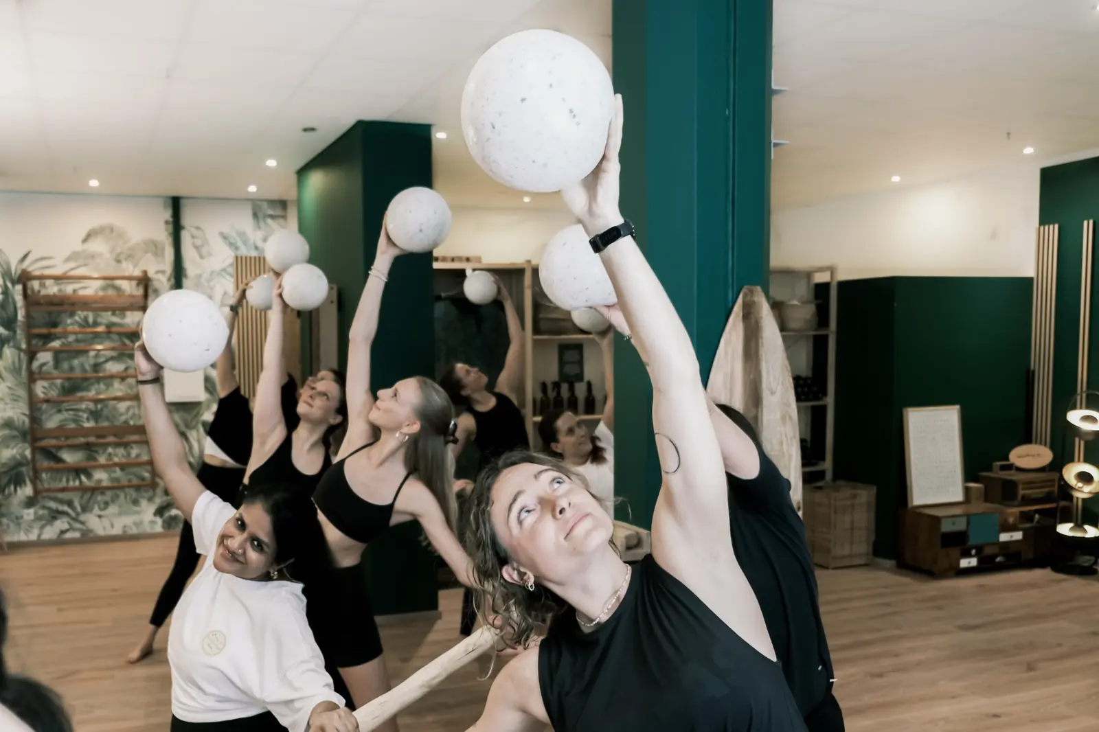 A group of women stretching with their arms raised in a mobility class