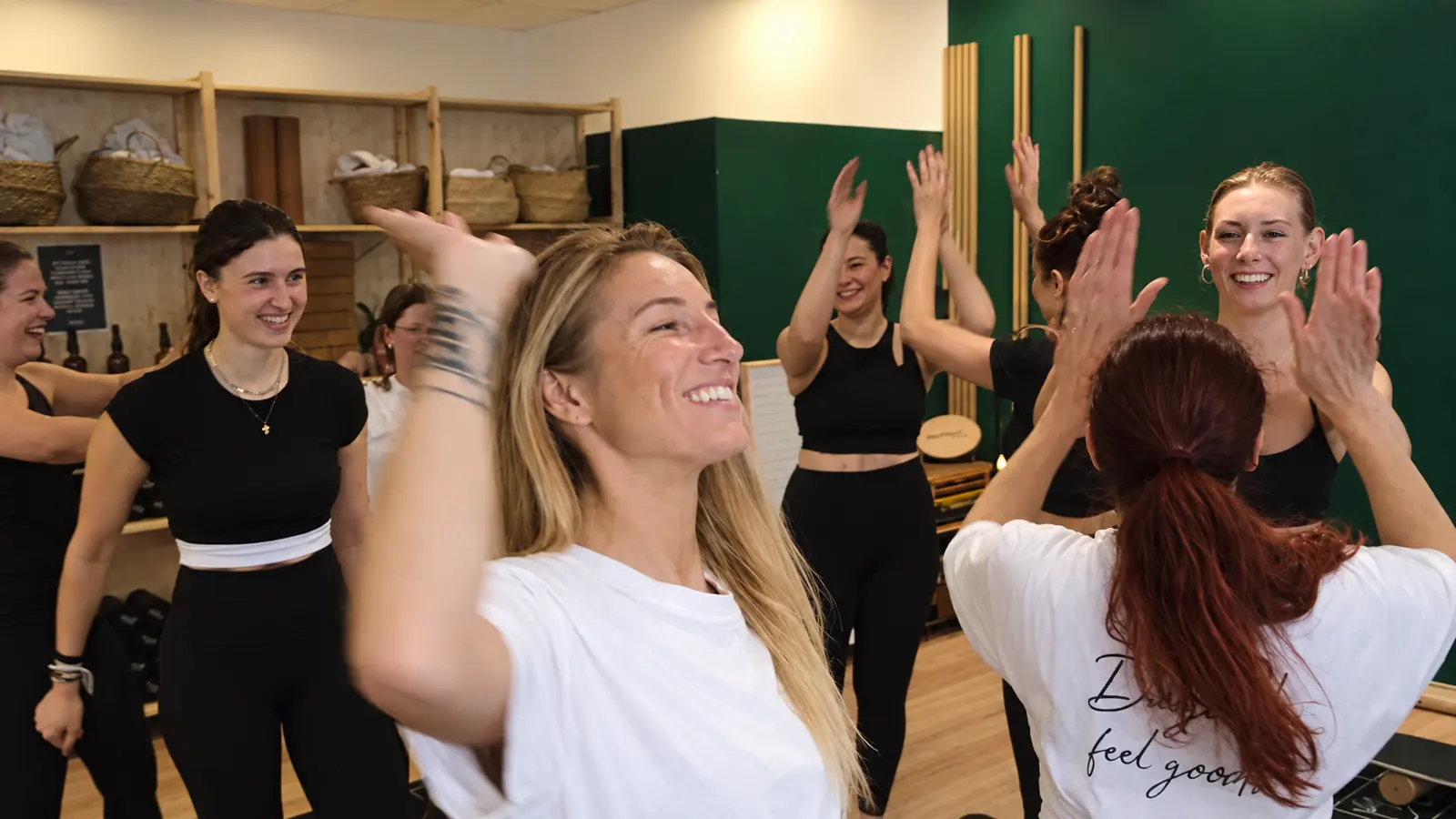 Women laughing and high-fiving each other after a class at The Good Gym