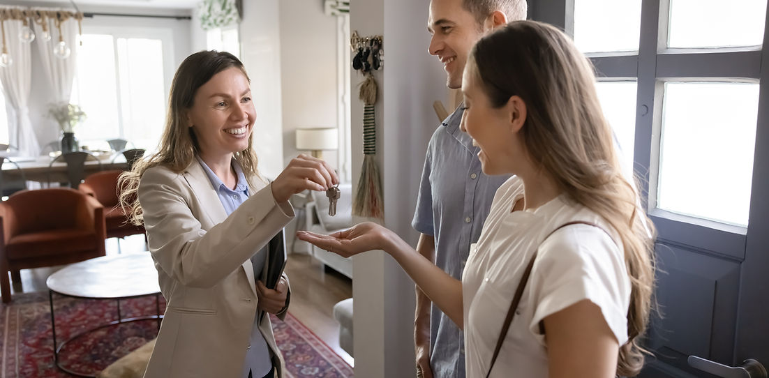 Woman giving keys to a couple