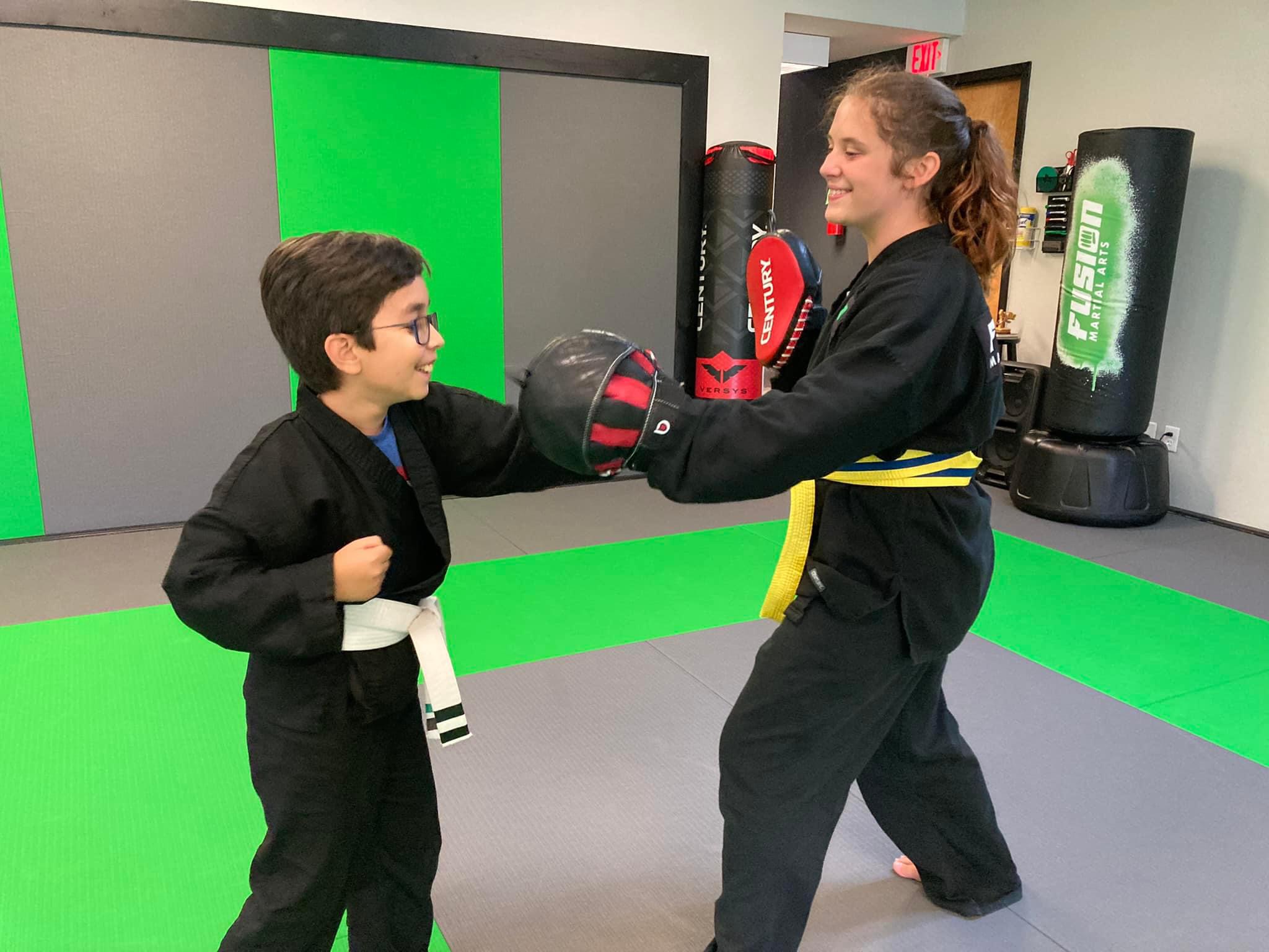 Kids training with partners on pads at Fusion Martial Arts
